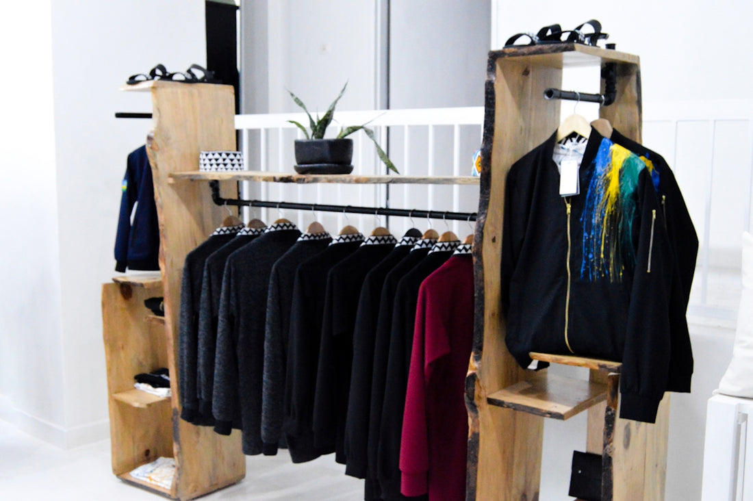 assorted clothes hanged on brown wooden rack