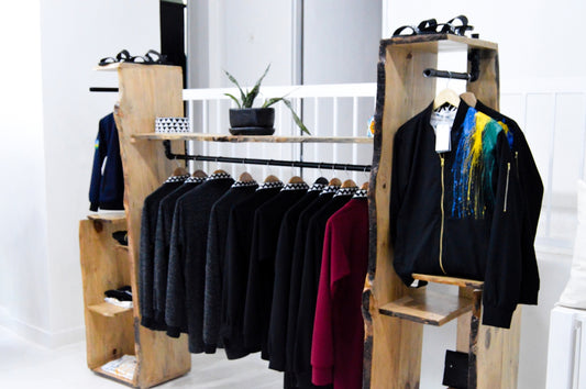 assorted clothes hanged on brown wooden rack