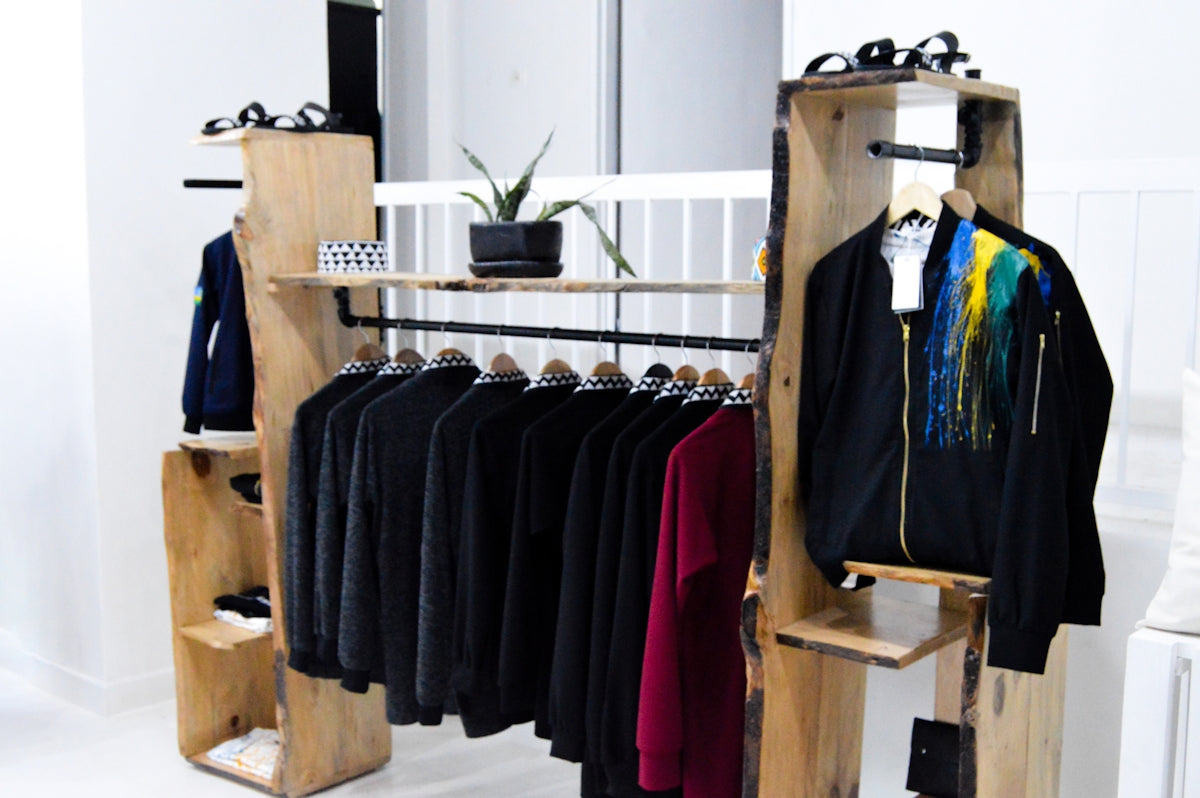 assorted clothes hanged on brown wooden rack