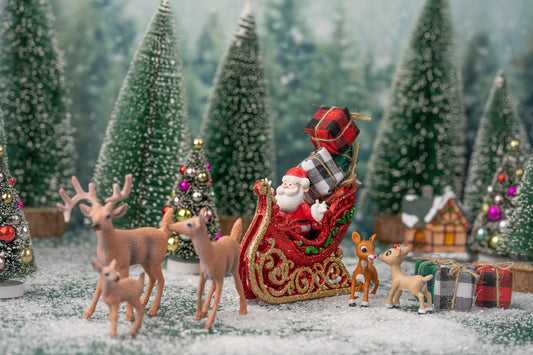 a person in a santa garment surrounded by reindeer
