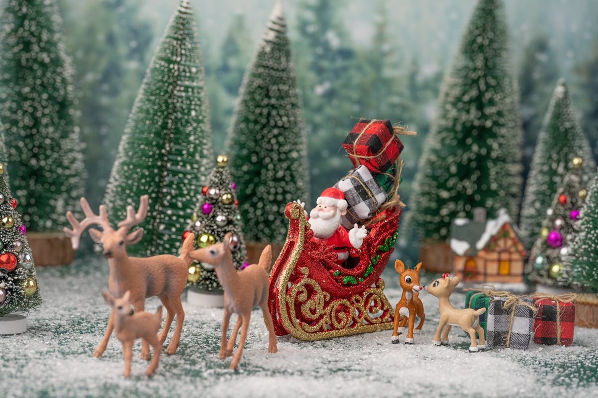 a person in a santa garment surrounded by reindeer