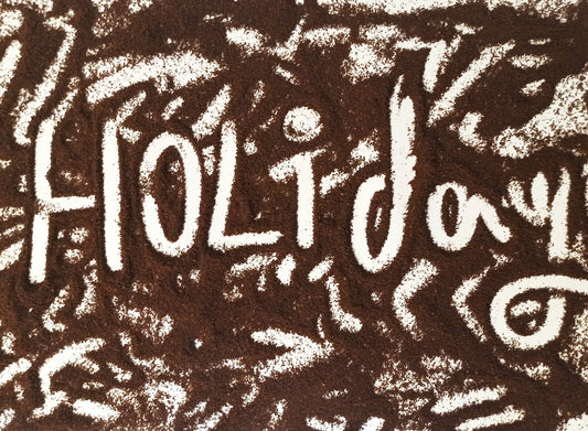 the word holiday written in white chalk on a brown background