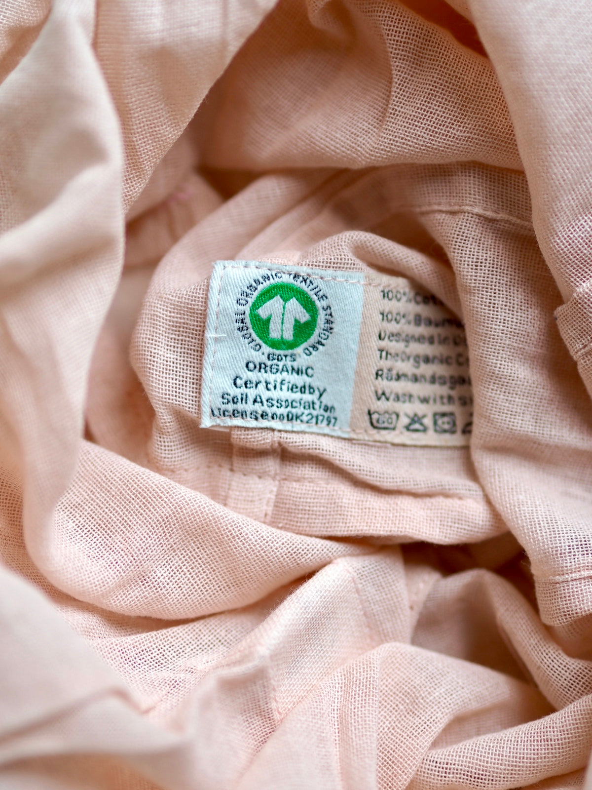 a close up of a label on a pink cloth