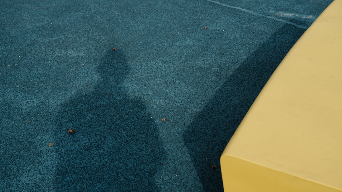 A shadow of a person on a blue carpet